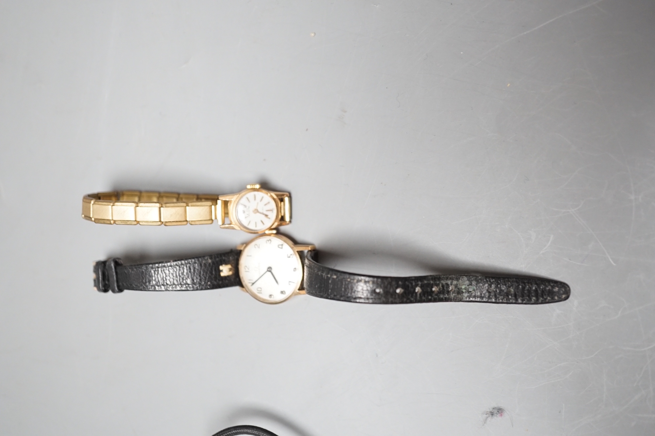 A lady's yellow metal Omega manual wind wrist watch, on a leather strap, with Omega box and a lady's 18k Mudu manual wind wrist watch on gilt metal strap.